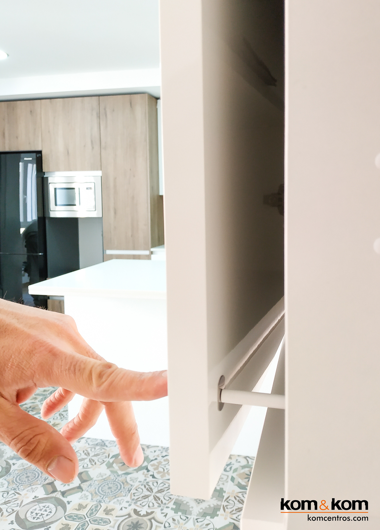 Detalle del mecanismo de apertura push de armario, mostrando la ausencia de tiradores